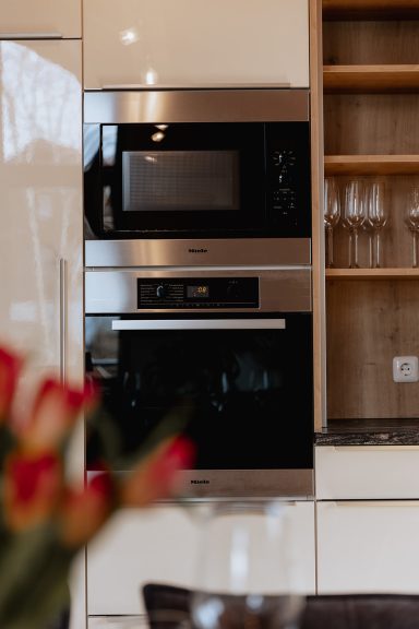 Moderne Küchengeräte in neutraler Farbgestaltung, einschließlich eines Mikrowellenofens.