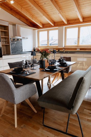 Moderne Esszimmer mit Holzdecke, Tisch, Stühlen und Pflanzen.