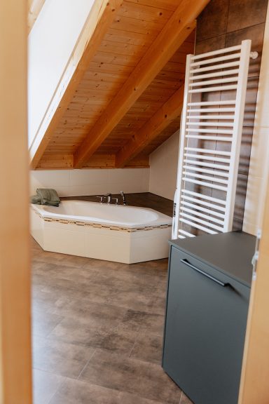 Ein moderner Badezimmerbereich mit Badewanne und einem Handtuchwärmer.